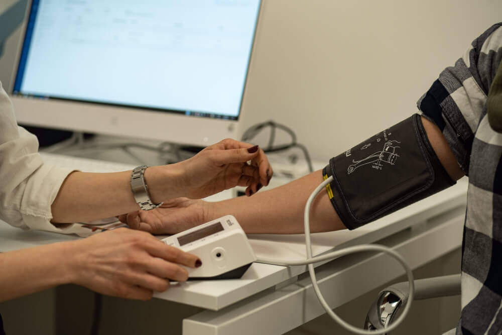 Doktor meri krvni pritisak pacijentu u ordinaciji