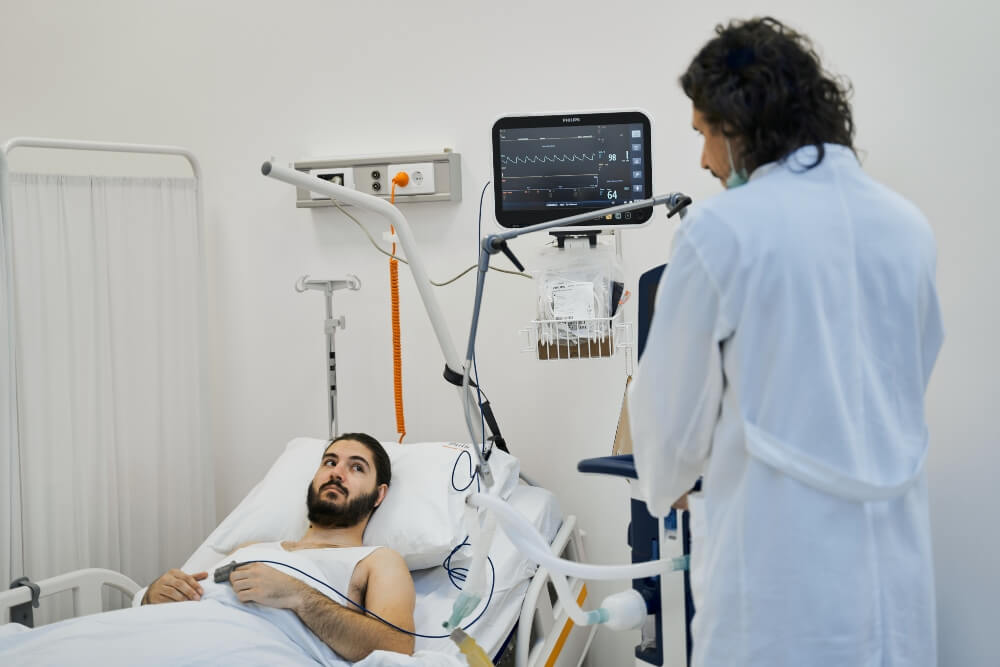 A doctor visits a patient lying in bed at the Puls Cardiology Center